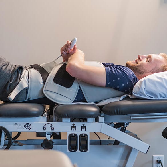 A patient resting on the spinal decompression table