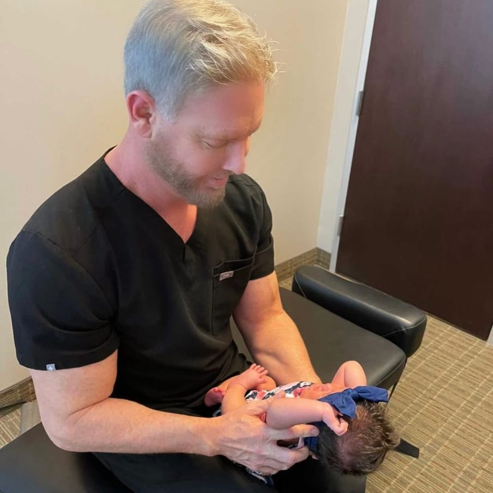 Dr. Currington gently adjusting an infant